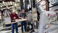 In this Thursday, Feb. 23, 2012, file photo provided by the U.S. Navy, Gary Bass, left, and Jim Poyner, from the Naval Surface Warfare Center, Dahlgren Division, take measurements after a successful test firing of an electromagnetic railgun prototype launcher.
