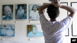 Tourist looks at portraits of former Khmer Rouge leaders, file photo. 