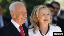 ປະທານາທິບໍດີຂອງ ອິສຣະແອລ Shimon Peres ຢືນຮຽກກັບທ່ານ​ນາງ ຮິ​ລ​ແລຣີ ຄລິນ​ຕັນ ລັດຖະມົນຕີ​ການຕ່າງປະ​ເທດ​ສະຫະລັດ ​ກ່ອນຈະເຂົ້າພົບປະກັນ ຢູ່ກຸງ Jerusalem ໃນວັນທີ 16 ກໍລະກົດ, 2012 ມື້ນີ້