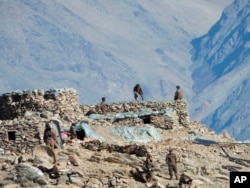 FILE - This photograph provided by the Indian Army, according to them shows Chinese troops dismantling their bunkers at Pangong Tso region, in Ladakh along the India-China border, Feb.15, 2021.