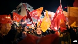 Supporters of President Recep Tayyip Erdogan wave flags in Istanbul, Sunday, March 31, 2019. 