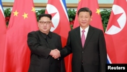지난 5월 중국 다롄을 방문한 북한 김정은 국무위원장이 시진핑 중국 국가주석과 만나 악수하고 있다.