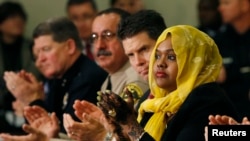FILE - Deeqo Jibril (right) applauds United States Vice President Joe Biden after Biden's opening remarks at a roundtable on countering violent extremism at the White House in Washington, Feb. 17, 2015.