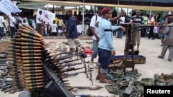An October 2009 photo shows Nigerian militant youths displaying weapons surrendered by former militants at an arms collection center in the oil hub Port Harcourt.