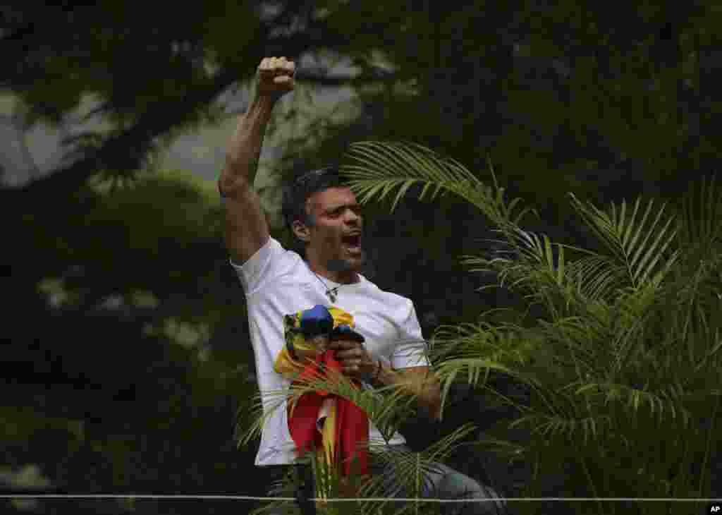 베네수엘라 야권지도자 레오폴도 로페스가 카라카스의 자택에서 밖에 모인 지지자들을 향해 주먹을 들어보이고 있다. 로페스는 3년 이상 수감됐다가 가택연금으로 풀려났다.