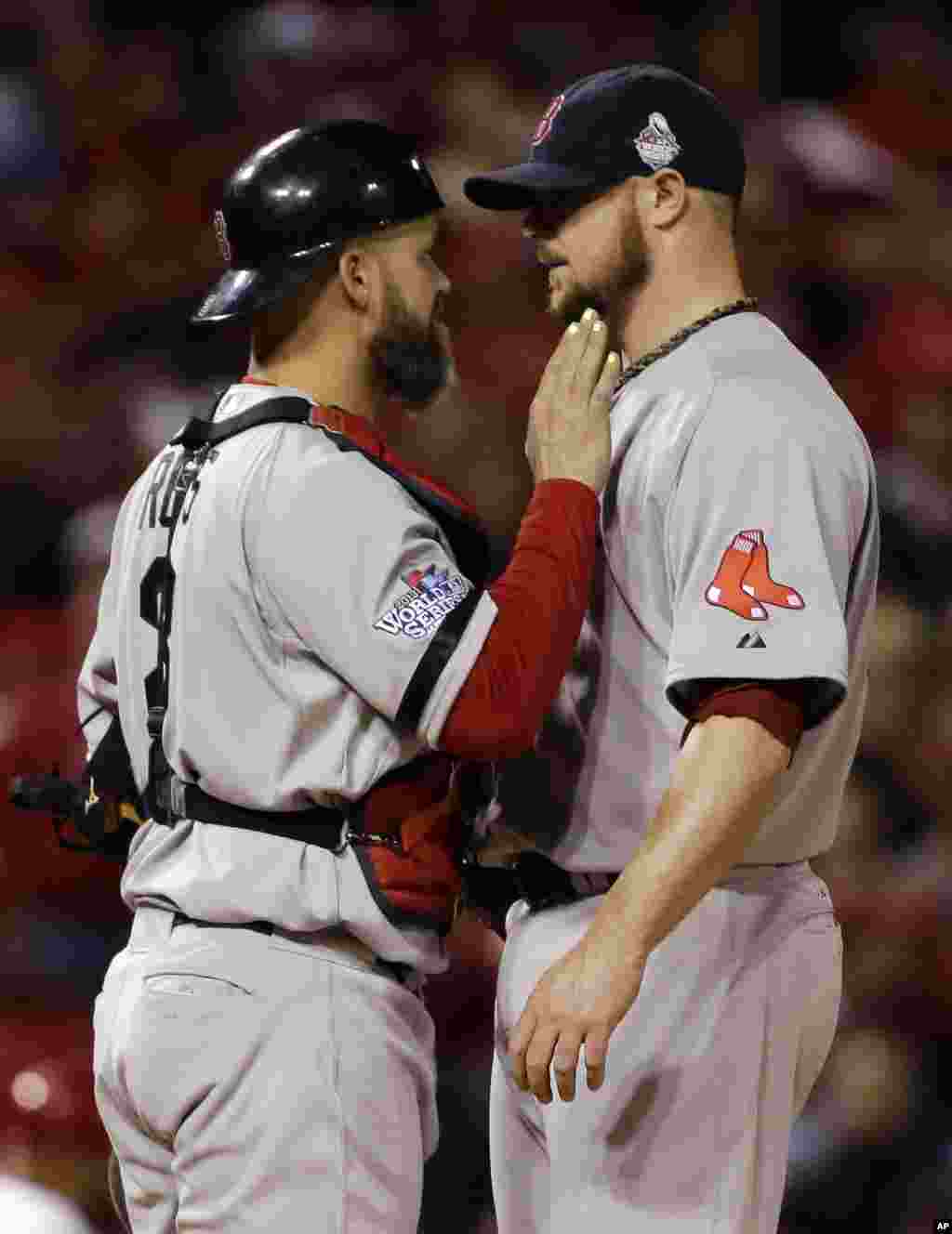 Boston Red Sox catcher David Ross talks to starting pitcher Jon Lester during the eighth inning of Game 5 of baseball's World Series against the St. Louis Cardinals, Oct. 28, 2013.