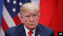 President Donald Trump listens to Japan's Prime Minister Shinzo Abe speak during their meeting, Friday, Nov. 30, 2018 in Buenos Aires, Argentina.