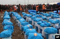 Displaced Iraqis, who fled fighting between Iraqi security forces and Islamic State militants, gather to receive humanitarian aid at a camp for internally displaced people in Hamam al-Alil, some 10 kilometers south of Mosul, Iraq, March 2, 2017.