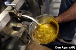 CBD oil flows into a large container during the extraction process from hemp plants at New Earth Biosciences in Salem, Oregon.