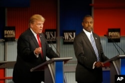 FILE - Donald Trump speaks as Ben Carson listens during the Republican presidential debate at the Milwaukee Theatre, Nov. 11, 2015, in Milwaukee