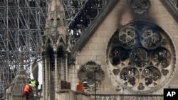 Experts inspect the damaged Notre Dame cathedral after the fire in Paris, April 16, 2019, assessing the blackened shell of Paris' iconic cathedral to establish next steps to save what remains after a devastating fire destroyed much of the almost 900-year-old building. 