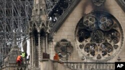 FILE - Experts inspect the damaged Notre Dame cathedral after the fire in Paris, April 16, 2019, assessing the blackened shell of Paris' iconic cathedral to establish next steps to save what remains after a devastating fire destroyed much of the almost 900-year-old building.