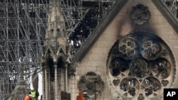 Experts inspect the damaged Notre Dame cathedral after the fire in Paris, April 16, 2019, assessing the blackened shell of Paris' iconic cathedral to establish next steps to save what remains after a devastating fire destroyed much of the almost 900-year-old building. 