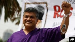 Malaysian cartoonist Zulkiflee Anwar Alhaque, better known as Zunar, wearing a prison outfit and plastic handcuffs poses for photographers prior to launching his book in Petaling Jaya, Malaysia, Feb. 14, 2015.