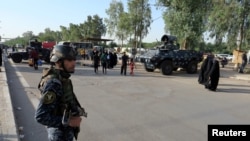 FILE - A member of Iraq's security forces stands guard in Baghdad's Kadhimiya district, May 2, 2016. Additional personnel has been deployed to prevent a repeat of recent protests.