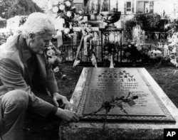 Vernon Presley, Elvis Presley's father, places a rose on his son's grave Nov. 24, 1977 as newspeople were permitted inside the grounds at Graceland in Memphis, Tenn. for the first time since Elvis' funeral.