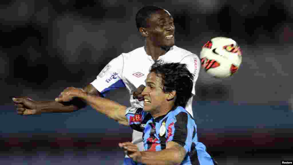 Victor Ferreira (mbele) timu ya Real Garcilaso ya Peru akiminyana kunyakua mpira kutoka kwa Efrain Cortes wa timu ya Nacional ya Uruguay wakati wa mchuano wa kombe la Libertadores mjini Montevideo, Mei 9, 2013.