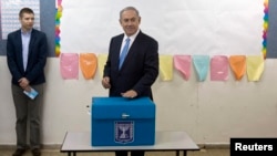 Le Premier minstre sortant israëlien Benjamin Netanyahu place son bulletin de vote dans l'urne pour les élections législatives en Israël, à Jérusalem, mardi 17 mars 2015.