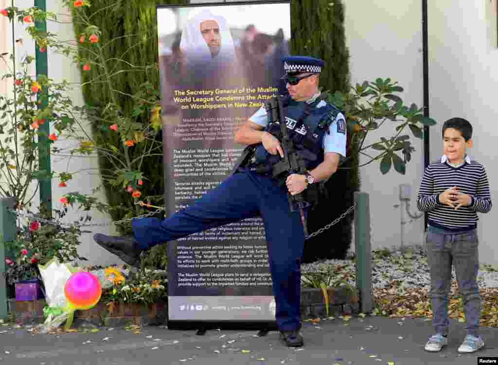 A police officer joins in a children&#39;s ball game as they wait for Britain&#39;s Prince William to finish his visit at Masjid al Noor in Christchurch, New Zealand.