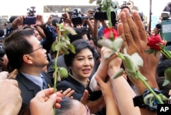 Thailand's former Prime Minister Yingluck Shinawatra, center, walks through supporters as she leaves the Supreme Court in Bangkok, Thailand, Tuesday, May 19, 2015.