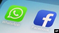 FILE - This Feb. 19, 2014, file photo, shows WhatsApp and Facebook app icons on a smartphone in New York. 