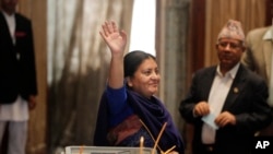 President Bidhya Bhandari, the country's first female president, waves after casting her vote alongside Nepali lawmakers in Kathmandu, Oct. 28, 2015.