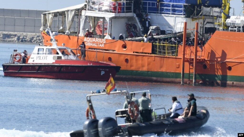 Des migrants se tiennent sur le pont de l'Aquarius alors que le navire entre dans le port de Valence, le 17 juin 2018.