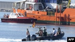 Des migrants se tiennent sur le pont de l'Aquarius alors que le navire entre dans le port de Valence, le 17 juin 2018.