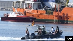 Des migrants se tiennent sur le pont de l'Aquarius alors que le navire entre dans le port de Valence, le 17 juin 2018.