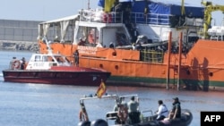 Des migrants se tiennent sur le pont de l'Aquarius alors que le navire entre dans le port de Valence, le 17 juin 2018.