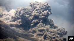 Gunung Sinabung melepaskan uap panas, terlihat dari desa Payung, Sumatera Utara (3/2). (AP/Binsar Bakkara)