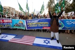 A supporter of religious and political party Jamaat-e-Islami chants slogans with others as he stands on Israeli flag during a protest against U.S. President Donald Trump's decision to recognize Jerusalem as the capital of Israel, in Karachi, Pakistan, Dec. 7, 2017.