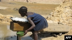 A girl separates gold dust from sand extracted by miners at the Nadom Koundo site near the village of Kette, some 40 kms from the eastern Cameroonian town of Batouri, June 2, 2008. Authorities are trying to get child miners back to school.