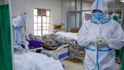 FILE - In this Aug. 20, 2021 photo, medical workers prepare to remove the body of a coronavirus victim in the intensive care unit of a hospital in Machakos, Kenya.