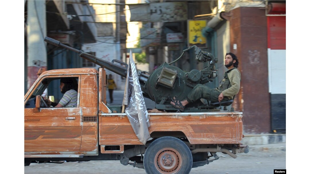 Members of al Qaeda's Nusra Front ride on a pick-up truck mounted with an anti-aircraft weapon in the town of the northwestern city of Ariha, after a coalition of insurgent groups seized the area in Idlib province, May 29, 2015.