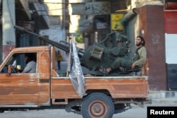 Members of al Qaeda's Nusra Front ride on a pick-up truck mounted with an anti-aircraft weapon in the town of the northwestern city of Ariha, after a coalition of insurgent groups seized the area in Idlib province, May 29, 2015.