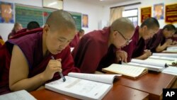 Tibetan Buddhist nuns read from their textbooks as they attend a Chinese language learning class at the Tibetan Buddhist College near Lhasa in western China's Tibet Autonomous Region, Monday, May 31, 2021. (AP Photo/Mark Schiefelbein)
