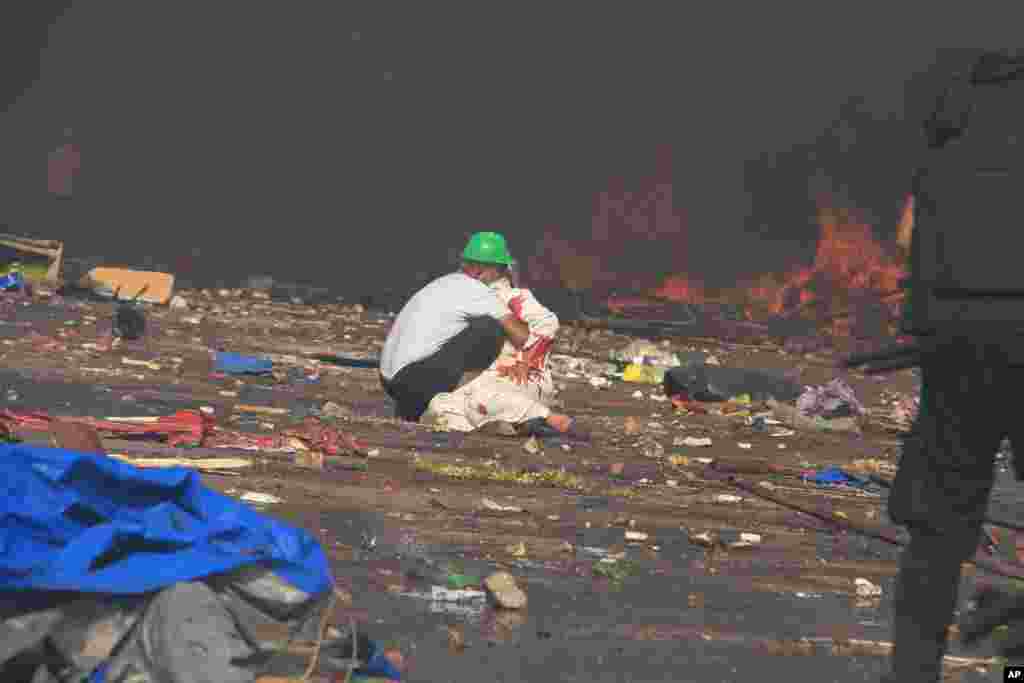 A protester comes to the aid of a wounded comrade as security forces clear a sit-in by supporters of ousted Islamist President Mohammed Morsi in the eastern Nasr City district of Cairo, Egypt, August 14, 2013.&nbsp;