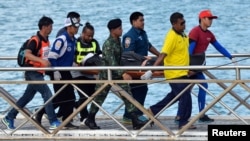 Para petugas penyelamat Thailand menggotong tubuh korban dengan tandu, setelah sebuah kapal di pulau tujuan wisata Phuket, Thailand karam tanggal 6 Juli 2018 (foto: Reuters/Sooppharoek Teepapan)