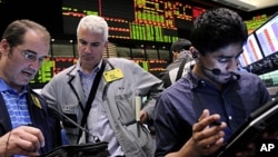 Traders work in the crude oil and natural gas options pit at the New York Mercantile Exchange in New York, (File June 29, 2011).