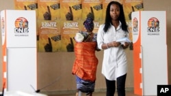 Voters prepare for casting their votes at a polling station as the country goes to the polls in Maputo, Mozambique, Oct. 15, 2014. 