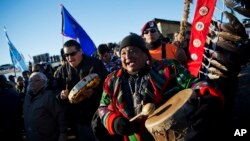 FILE - Dan Nanamkin of the Colville Nez Perce Native American tribe in Nespelem, Washington, right, drums with a procession through the Oceti Sakowin camp in Cannon Ball, North Dakota, Dec. 4, 2016.