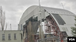 FILE - A new sarcophagus (shown under construction in 2014), the world's largest movable object, is to be placed over the Chernobyl plant in 2017, March 20, 2014. (S. Herman/VOA)