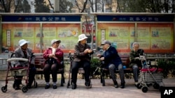 FILE - A group of elderly women rest in their wheelchairs at a residential compound in Beijing, China, March 31, 2016.