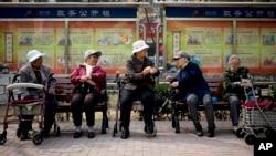 FILE - A group of elderly women rest in their wheelchairs at a residential compound in Beijing, China, March 31, 2016.