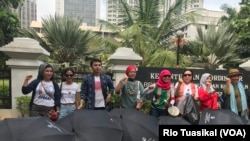 Aktivis Aliansi Remaja Independen (ARI) Aditya Septiansyah (ketiga kiri) berpose di depan Kementerian Pemberdayaan Perempuan dan Perlindungan Anak yang dilewati rute pawai, Jakarta, Sabtu, 8 Desember 2018. (Foto: Rio Tuasikal/VOA)