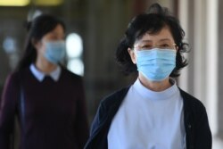 Kang Son Bi (kanan), istri Mun Chol Myong, pria Korea Utara yang menghadapi kemungkinan ekstradisi dari Malaysia ke AS atas tuduhan pencucian uang, tiba di kompleks pengadilan Duta di Kuala Lumpur, Malaysia, 8 Oktober 2020.