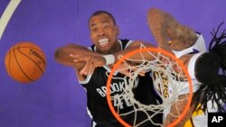 Jason Collins, de los Nets de Brooklyn, intenta recuperar un rebote que buscaba Jordan Hill, de los Lakers, en su debut como jugador abiertamente gay.