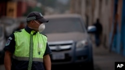 Un agente de tránsito cubre su cara con una máscara para protegerse de la ceniza lanzada por el volcán de Fuego en Antigua Guatemala.