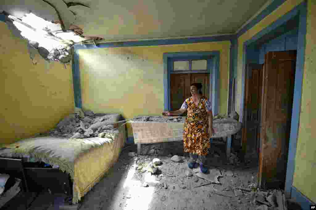 A local woman shows damage in her house after the shelling by Armenian forces in the Tovuz region of Azerbaijan.